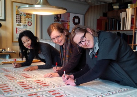 Ngan Siu-Mui, Susan Scott and Hélne L'Heureux signing collector's Rem Yeat Stamp Sheet